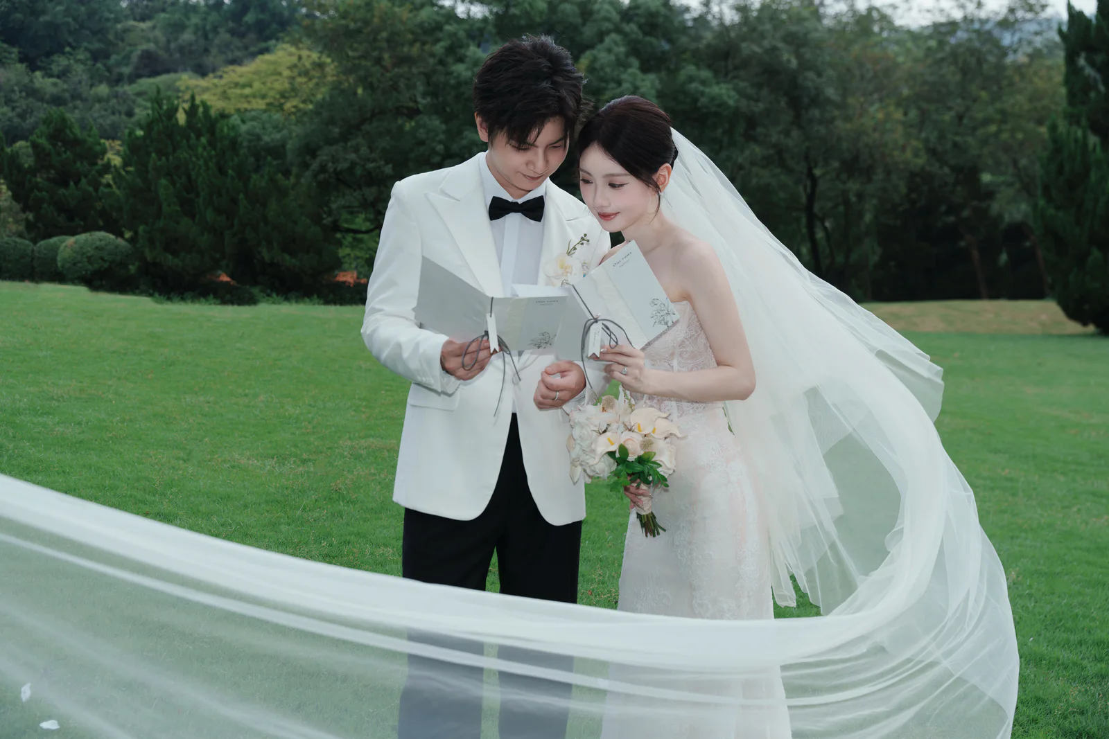 新人在草坪上翻看婚礼书册