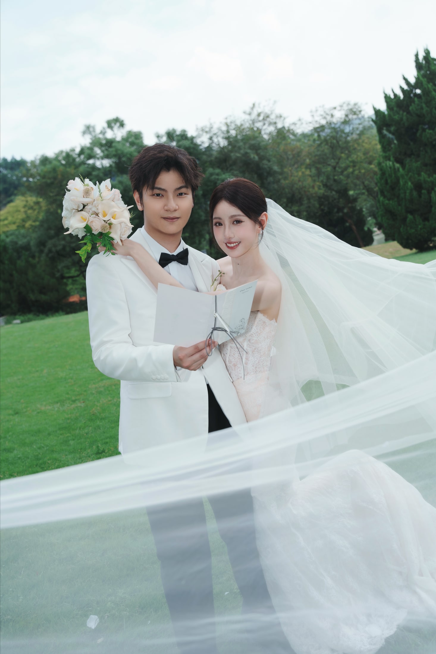 陈晓楠与林心钰在草坪婚礼场景中相依，头纱随风展开
